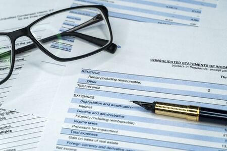 Data analyzing in stock market: on the charts and quotes prints, the eyeglasses and a penの写真素材