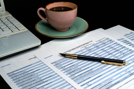 The report summarizes the results of business operations, pen, cup of coffee on desk of investor....