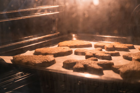 Christmas cookies baking in the oven. Christmas baking. Gingerbread biscuits on baking tray.の写真素材