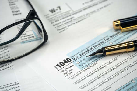 Filling US tax form. Tax form USA business income office concept. Tax Return Form 1040の写真素材
