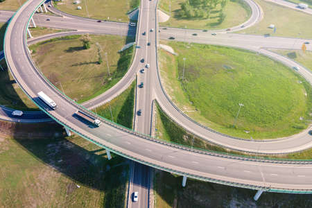 Aerial view of road interchange or highway intersection with busy urban traffic speeding on the...