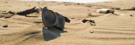 Old rusty beverage can in the sand desert. Pollution of nature recycle the trash. Environment Global...