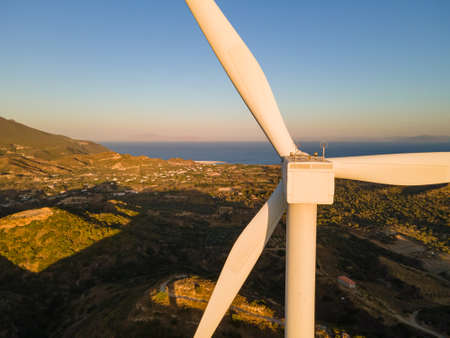 Wind turbine with blades in wind farm aerial view bright orange sunse