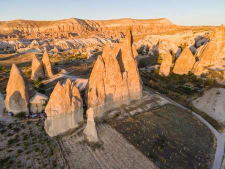 Sunset in Cappadocia red valley with fairy chimneys, Aerial drone flight over beautiful and ancient caveの写真素材
