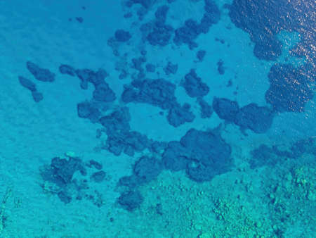 Background image of the turquoise sea. Deep sea and corals. Aerial drone shot of turquoise water -...