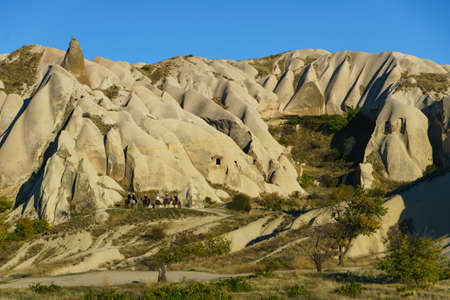 Sunset in cappadocia red valley landscape with horse riders, Beautiful rock formationの写真素材