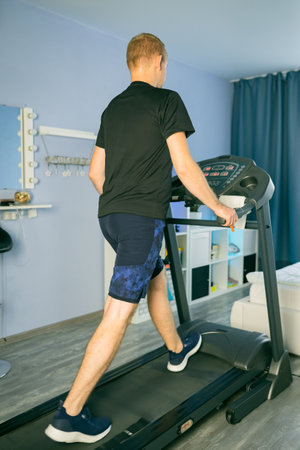 Man Treadmill Running In Home. Cardio Run Workout. Sportsman Jogging Treadmill Running. vertical...