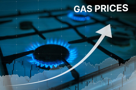 High prices for natural gas. Blue flame of burning natural gas from a gas stove and graph chart with...