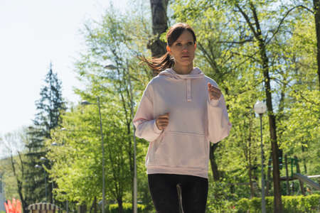 Woman runner running on stairs in city park, concept of training exerciseの写真素材