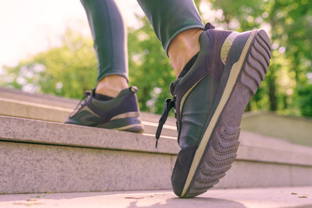 Woman athlete legs running up stairs training intense cardio work out exercise, female runner feet...