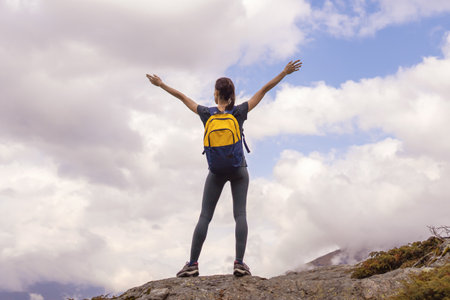 Woman stands on mountain top raised his hands pure nature enjoying the landscapeの写真素材