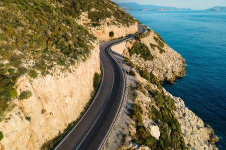 Aerial view of winding coastal road with mountains on one side and Mediterranean seaの写真素材