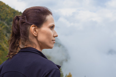 Woman rest in hike looking above cloud of highland mountainsの写真素材