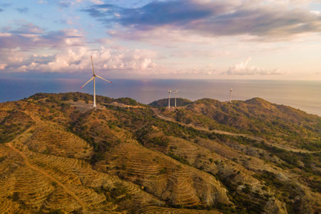 Aerial view of windmill turbines generating green energy electric, Establishing shot
