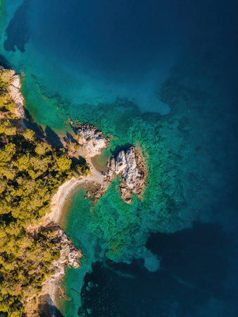 Rocky shore of Aegean sea, aerial top down view, verticalの写真素材