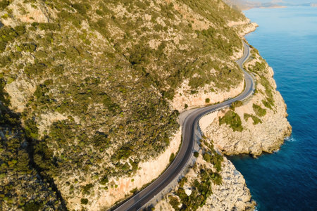 Aerial view of winding coastal highway with mountains on one side and Mediterranean seaの写真素材