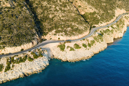 Aerial view of winding coastal highway with mountains on one side and Mediterranean seaの写真素材