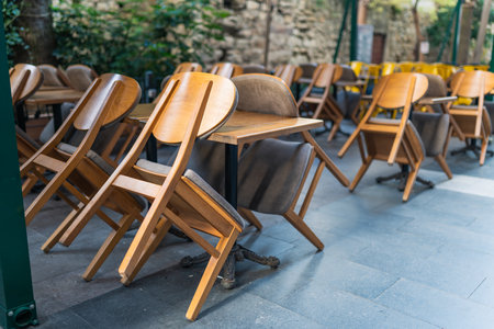 Stacked chairs and tables in front of a closed restaurant in the city center, follow the financial crisisの写真素材