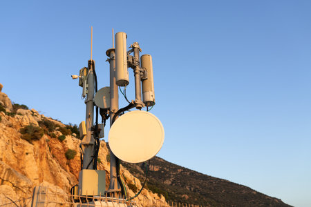 Close-up antenna repeater tower in mountain at sunset light. low angle view