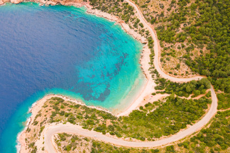 Scenic winding road coastal landscape in overcast weather, aerial shotの写真素材