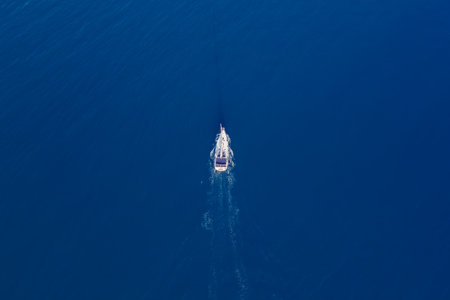 White sailing yacht in the middle of the boundless sea with calm water. Aerial top down viewの写真素材