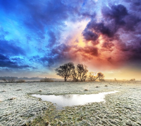 Frosted autumn meadow at dawn  Dramatic skyの写真素材