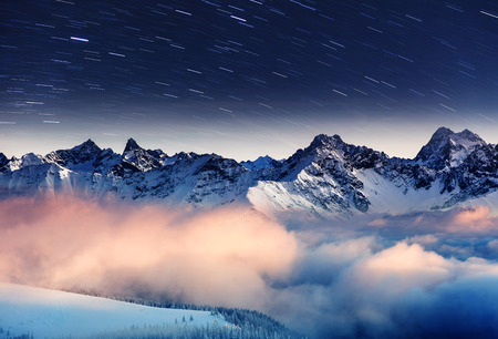 The Milky Way over the winter mountains landscape. Europe. Creative collage. Beauty world.
