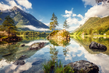 View on turquoise water and scene of trees on a rock island at Lake Hintersee. Location famous resort National park Berchtesgadener Land, Ramsau, Bavaria, Alps. Europe. Artistic picture. Beauty world.の写真素材