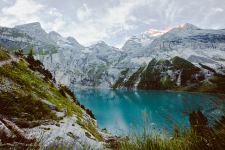 Glacier pond Oeschinensee. Popular tourist attraction. Picturesque and gorgeous scene. Location Swiss alps, Kandersteg, Bernese Oberland, Europe. Vintage effect.の写真素材