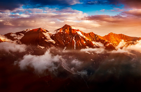 A look at the sunlit hills at twilight. Dramatic evening scene. Location place Grossglockner High...