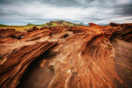 Red sandy rock with by magma formed by wind. Popular tourist attraction. Unusual and gorgeous scene. Location place Sudurland, cape Dyrholaey coast of Iceland, Europe. Artistic picture. Beauty world.の写真素材