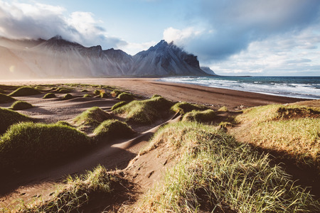 Unusual hills glowing by sunlight. Dramatic and gorgeous scene. Tourist attraction. Location Stokksnes cape, Vestrahorn.の写真素材