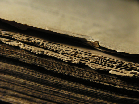 Old shabby book isolated over a black background. Historical museum exhibit. Cross process filter, retro and vintage style.の写真素材