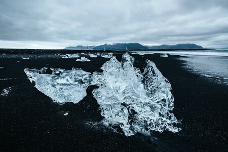 Amazing pieces of the iceberg sparkle. Location Jokulsarlon lagoon, Diamond beach, Vatnajokull national park, Iceland, Europe. Scenic image of popular tourist attraction. Discover the beauty of earth.の写真素材