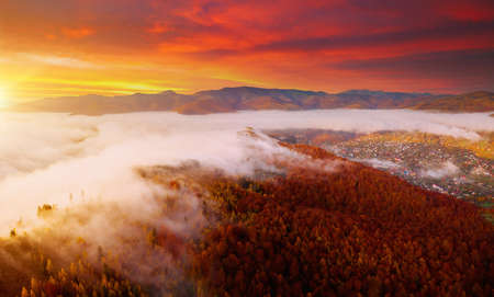 Epic sunset view in alpine foggy valley. Location place of Carpathian mountains, Ukraine, Europe. Picturesque wallpaper. Drone photography. Fresh vibrant colors. Discover the beauty of earth.の写真素材