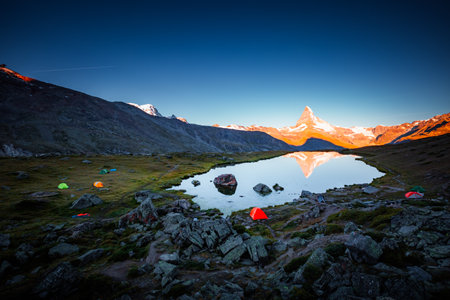 Famous peak Matterhorn (Cervino) in red sunlight. Location place Stellisee lake, Switzerland, Valais region, Swiss alps, Europe. Photo of popular tourist attraction. Discover the beauty of earth.の写真素材