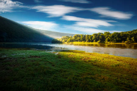 Idyllic summer morning with green meadow on the river. Location place Dnister or Dniester canyon of Ukraine, Europe. Vibrant photo wallpaper. Splendid nature photography. Discover the beauty of earth.の写真素材