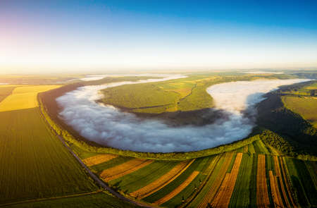 Fantastic view from a drone flying over the foggy river. Location place Dnister or Dniestr canyon of...