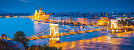 Scenic top view of the Hungarian Parliament and Chain Bridge on the Danube river at night. Location place Budapest, Hungary, Europe. Photo of popular tourist attraction of the world. Beauty of earth.の写真素材
