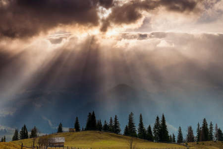 The sun's rays break through the clouds and illuminate the valley. Location place of Carpathian...