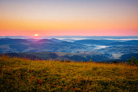 The sun sets over the mountain ranges. Location place Carpathian mountains, Ukraine, Europe. Perfect summertime wallpaper. Image of an magical sunset. Summer vacation. Discover the beauty of earth.の写真素材
