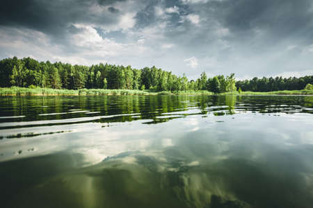 Great view of the quiet lake and green forest on a sunny day. Location place Small Polissya, Ukraine, Europe. Photo of nature concept. Perfect summertime wallpaper. Discover the beauty of earth.の写真素材