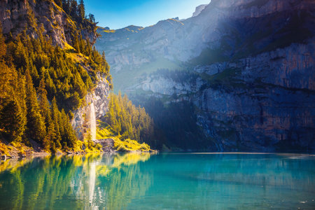 Splendid summer landscape with a waterfall near Oeschinensee lake. Location Swiss alps, Switzerland, Kandersteg district, Europe. photo wallpaper. Image of exotic place. Discover the beauty of earth.の写真素材