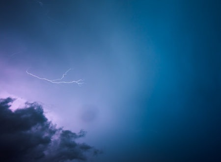 A strong storm with bright lightning illuminating ominous clouds. Exotic image of the texture of storm clouds. Adverse weather conditions. picturesque photo wallpaper. climate change. force of nature.の写真素材