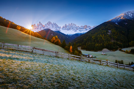 The sun's rays break through the peaks of the Odle Ridge in St. Magdalena village. Location Val di Funes (Villnob), Dolomite alps, Trentino-Alto Adige, Italy, Europe. Discover the beauty of earth.の写真素材