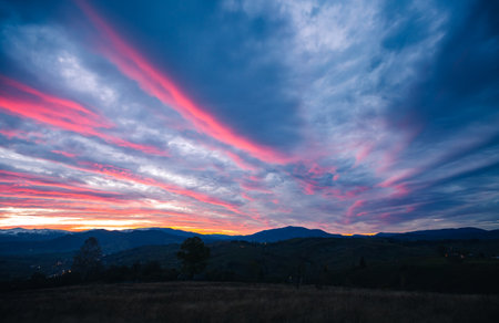 Gorgeous sunset with cloudy sky in the mountains. Photo of textured sky. Scenic image of dramatic light in summer weather. Breathtaking natural wallpaper background. Discover the beauty of earth.の写真素材