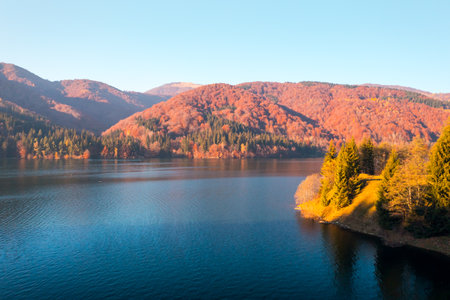 A magical view of the lake surrounded by mountains and an autumn forest from a height. Location place Carpathian mountains, Ukraine, Europe. Drone shot.の写真素材