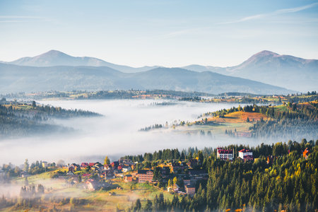 Impressive landscape with fog enveloping the valley from a bird's eye view. Location place Carpathian mountains, Ukraine, Europe. Aerial photography. Photo wallpaper Discovery of the beauty of earth.の写真素材