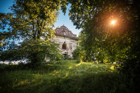 Ancient abandoned catholic church of 19th century in a Linden grove. Location place Ternopil region, Ukraine, Europe. Ruins of an old Polish church. Photo wallpaper Discovery of the beauty of earth.の写真素材