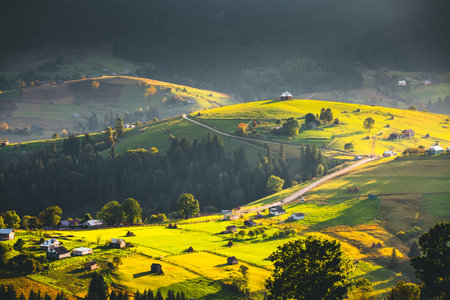 Distant mountain ranges and green pastures in the morning light. Location place Carpathian mountains, Ukraine, Europe. Image of attractive scene, photo wallpapers. Discovery of the beauty of earth.の写真素材